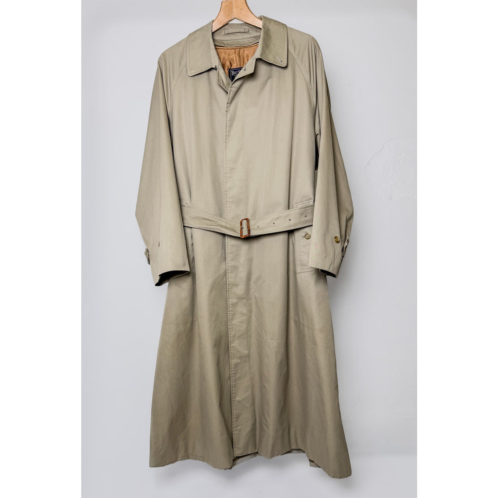 Beige trench coat on a hanger against a light gray background